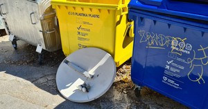 Antena satelitarna obok kontenerów na śmieci 