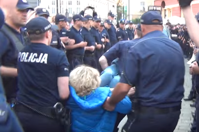 Policjanci wynoszący jedną z osób z kontrmanifestacji Obywateli RP